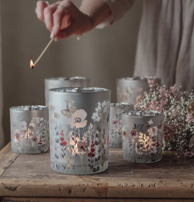 Bild av stämningsfulla ljuslyktor med blommönster på träbord
