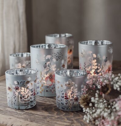 Bild av glaslyktor med botaniska motiv och torkade blommor