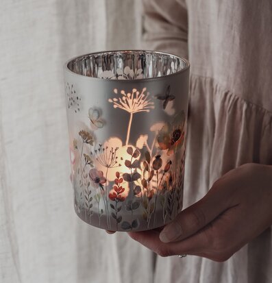 Bild på handhållen lykta med botaniskt motiv och mjukt ljus