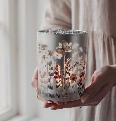 Bild av elegant glaslykta med blommor i ljust och rofyllt rum