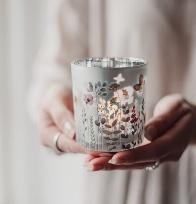 Bild på dekorativ ljuslykta med blommotiv i mjukt sken