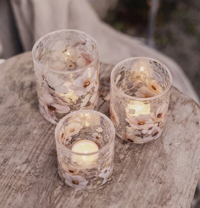 Bild på ljuslyktor med blommor och fjärilar på träbord