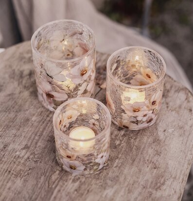 Bild av ljuslyktor med blommor på rustikt träbord utomhus