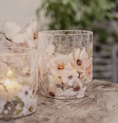 Bild av ljuslyktor i krackelerat glas med blommor och fjäril