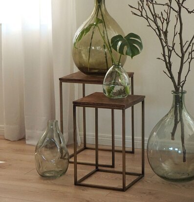 Bild med eleganta sidobord och gröna glasvaser i harmoni