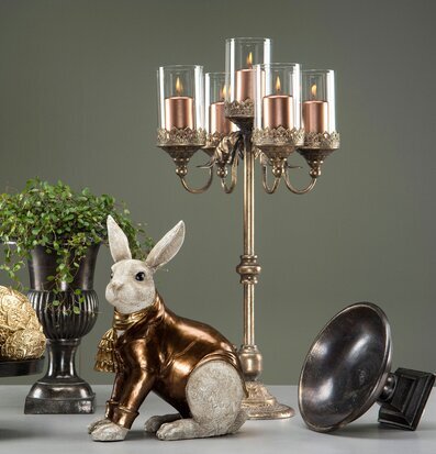 Bild på elegant kandelaber, kaninfigur och dekorativ dukning