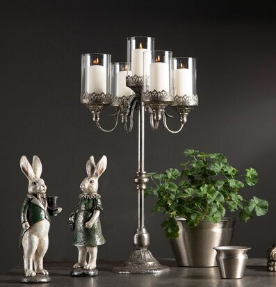 Bild av elegant stilleben med kandelaber, kaniner och grönska