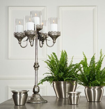Bild av stilrent bord med silverkandelaber och grönväxter