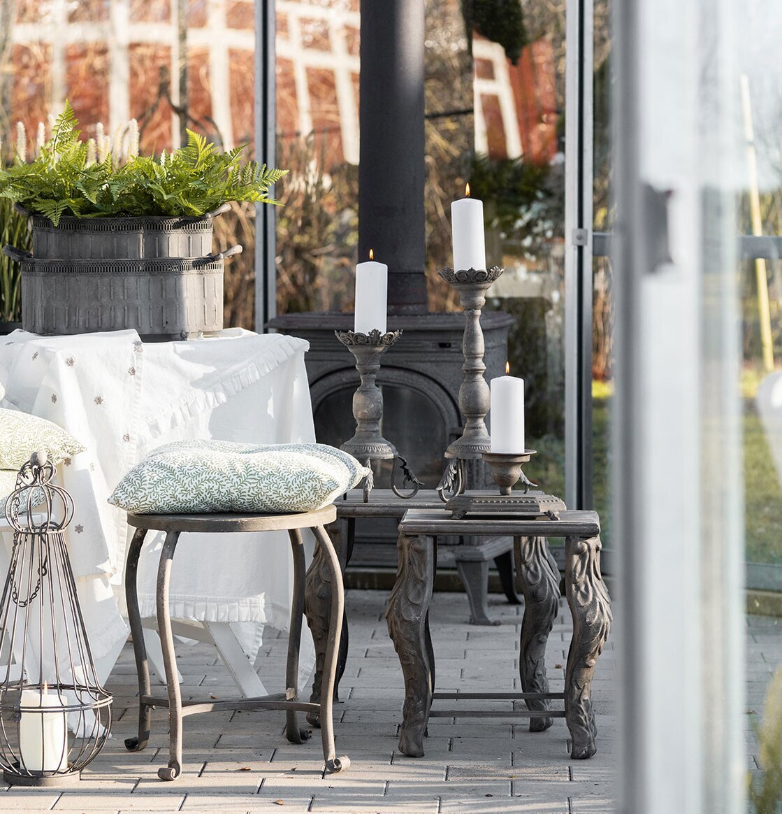 Bild av ljust uterum med metallbord, växter och vårkänsla