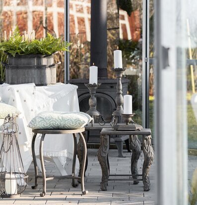 Bild av ljust uterum med metallbord, växter och vårkänsla