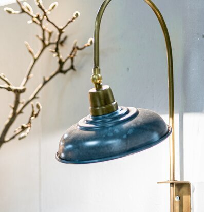 Bild på stilren vägglampa i emalj med guldtonat väggfäste