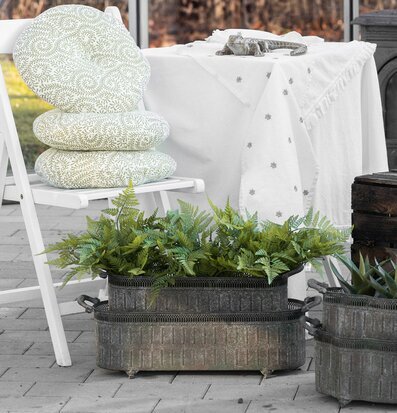 Bild av harmonisk uteplats med metallkruka och gröna växter