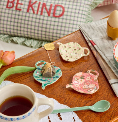 Bild av färgglad frukostmiljö med tekannor, ägg och blommor