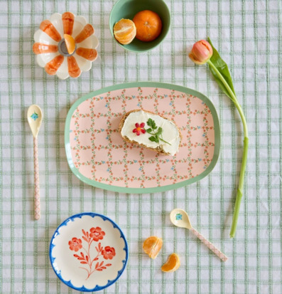 Bild på dukat bord med pastellfärgat porslin och frukost