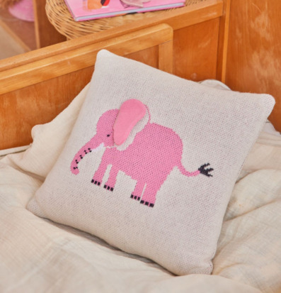 Bild av mysigt barnrum med rosa elefantkudde och lekfull inredning