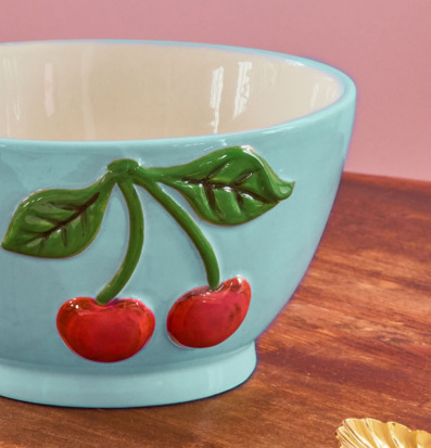 Bild av keramikskål med körsbärsdekor mot rosa bakgrund