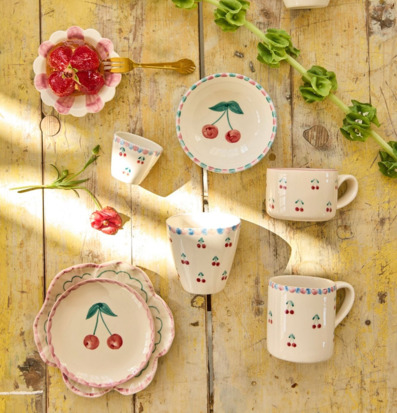 Bild av keramikservis med körsbärsmotiv på rustikt träbord