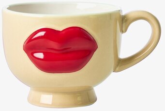 Bild på gul keramikmugg med röda läppar och vit insida