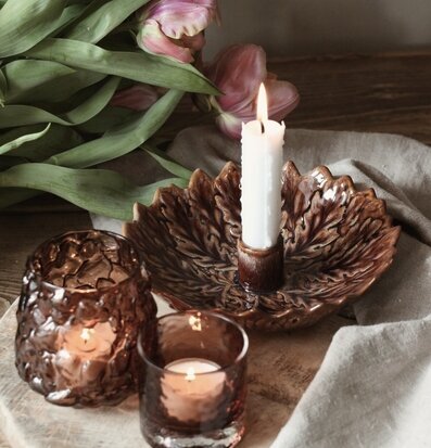 Bild på harmoniskt stilleben med ljusstake, glas och tulpaner