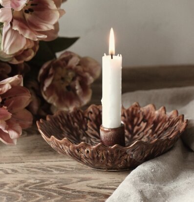 Bild av harmoniskt stilleben med ljusstake, tulpaner och linnetyg