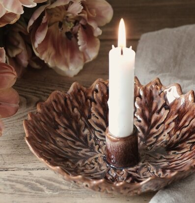 Bild av keramikljusstake med tända ljus och tulpaner