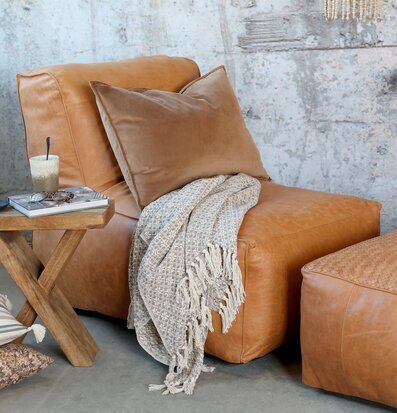 Bild av harmoniskt vardagsrum med läderfåtölj och sidobord