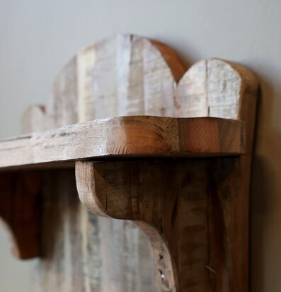 Bild på detaljrik vägghylla i trä med handgjord känsla