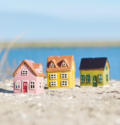 Bild av färgglada husformade ljuslyktor vid strand och hav