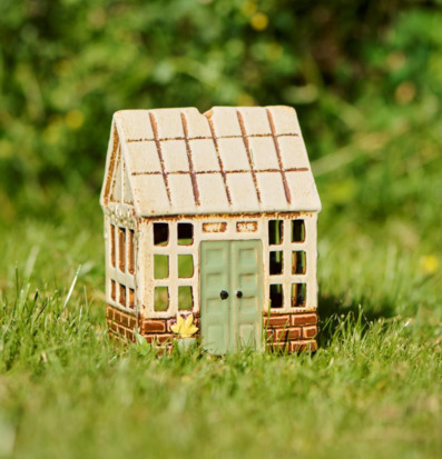 Bild av dekorativ ljuslykta som litet orangeri i gräset