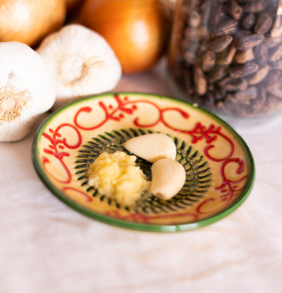 Bild på keramisk rivplatta med vitlök och lök i köksmiljö