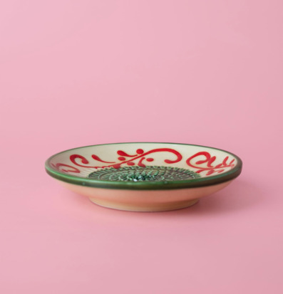 Bild av keramisk rivplatta med dekor och grön ralyta