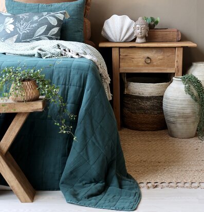 Bild på harmoniskt sovrum med grönt överkast och naturtoner