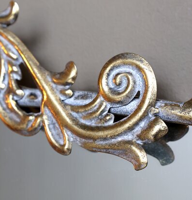 Bild på antik mässingsspegel med dekorativ ram och ornament