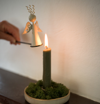 Bild av ljussläckare som släcker ljus i stämningsfull miljö