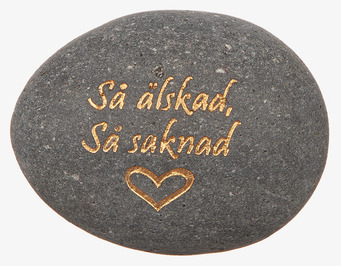 Bild på grå minnessten med guldtext och hjärtsymbol