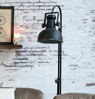 Bild av industriell golvlampa och rustik inredning i vardagsrum