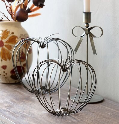 Bild av antikmässing pumpor, ljusstake och höstlig blomvas