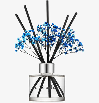 Bild av doftpinnar med blå blommor och stilren glasflaska