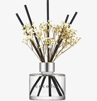 Bild av stilren doftspridare med svarta pinnar och vita blommor