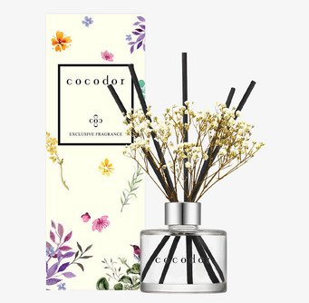 Bild på eleganta doftpinnar med vita blommor och blomförpackning