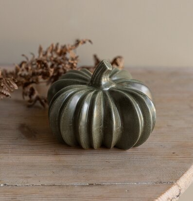 Bild på dekorativ grön keramikpumpa på ljust träbord