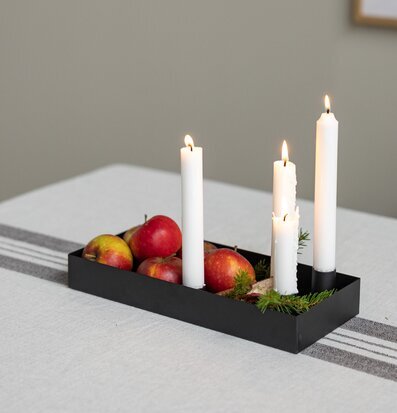 Bild på modern ljusstake med säsongsdekoration på matbord
