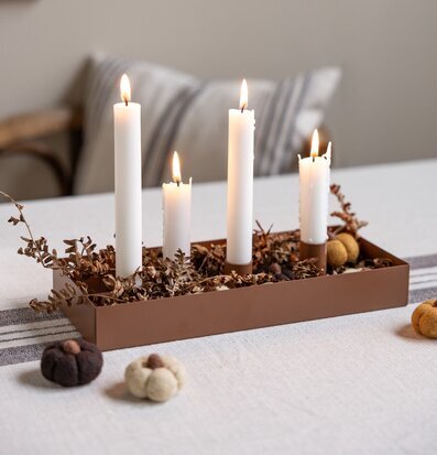Bild på brun rektangulär ljusstake med höstdekoration och ljus