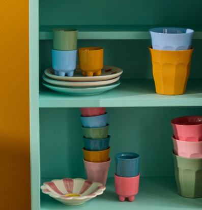 Bild av pastellfärgad hylla med äggkoppar och färgglada muggar