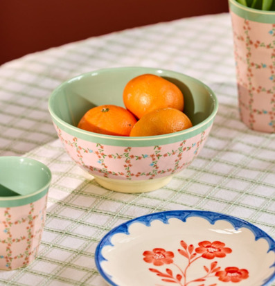 Bild av dukat bord med pastellfärgad keramik och frukter