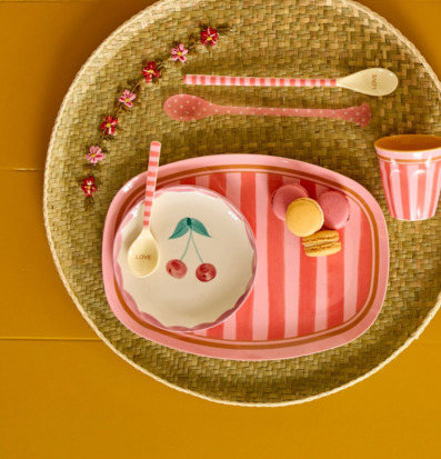 Bild av lekfull servering med randiga tallrikar och macarons