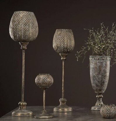 Bild på stilrena ljuslyktor med bladmönster och vas på bord
