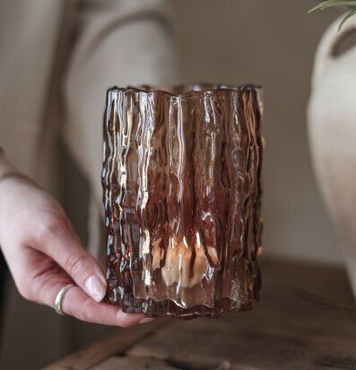 Bild av kastanjebrun ljuslykta i glas på rustikt träbord