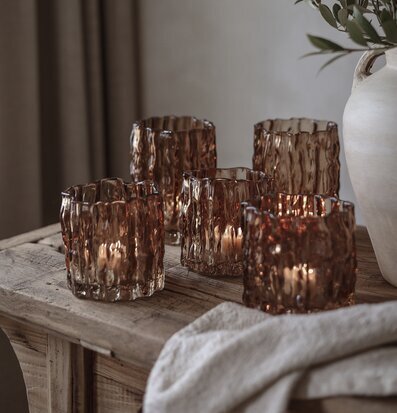 Bild av stilleben med bruna ljuslyktor, träbord och grönska