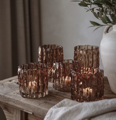 Bild: Rustikt träbord med bärnstensfärgade ljuslyktor och grönska